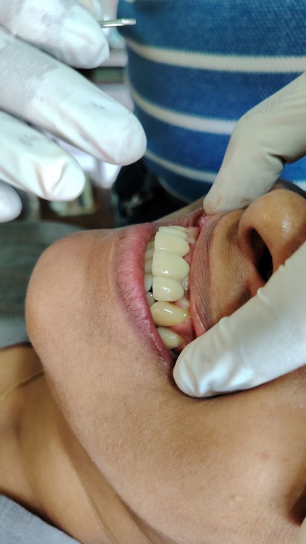 Gloved hands carrying out a close dental examination